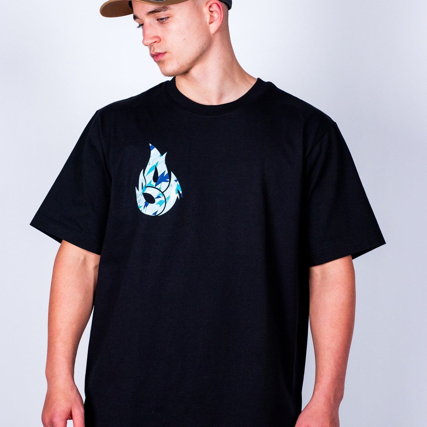 Person wearing a black t-shirt with a blue camo graphic design on a plain background