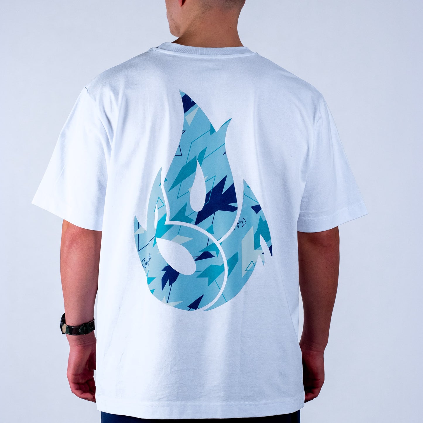 White t-shirt with blue and black camo abstract design on the back, worn by a person.