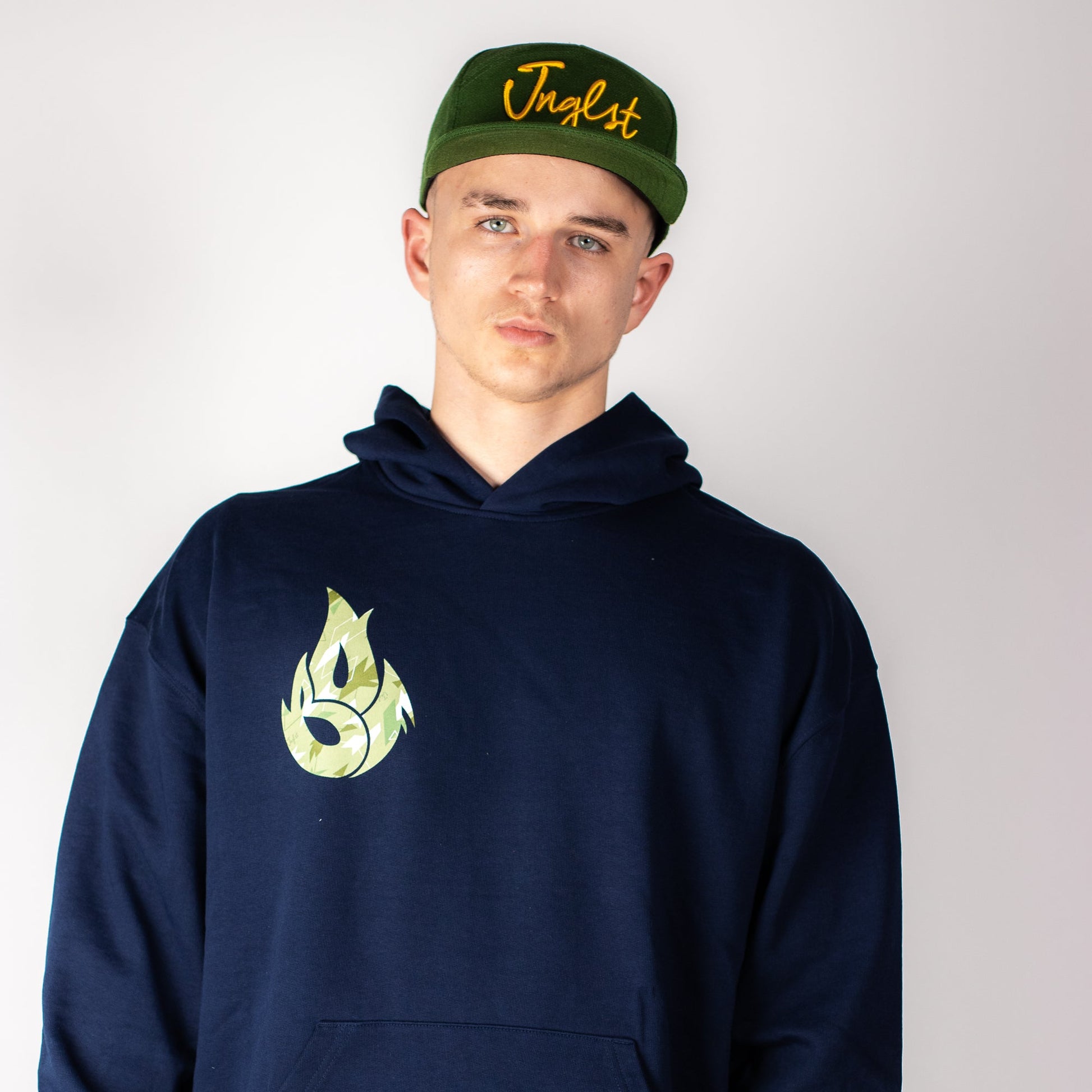Person wearing a navy Born Outta Fire Collab hoodie with a logo and a green cap with text on a plain background