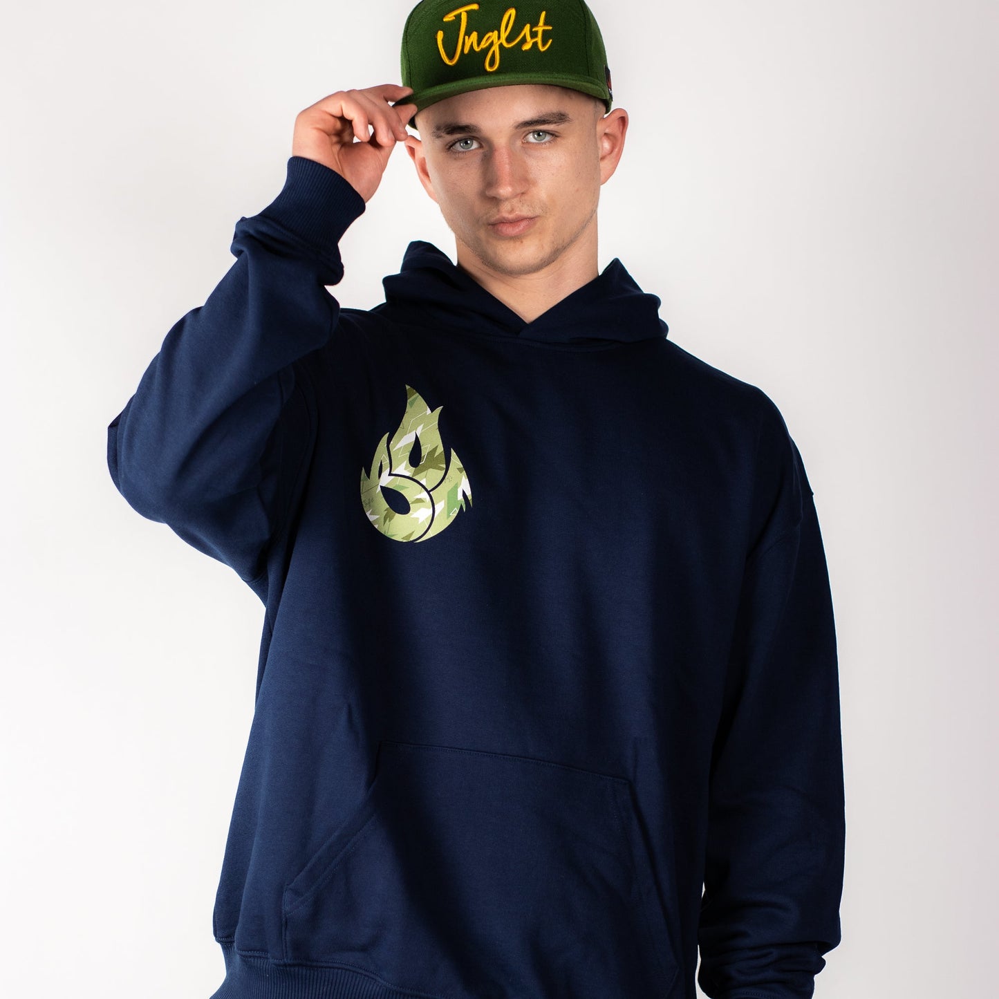 Person wearing a navy Junglist hoodie with a green logo and a green cap with yellow text on a white background