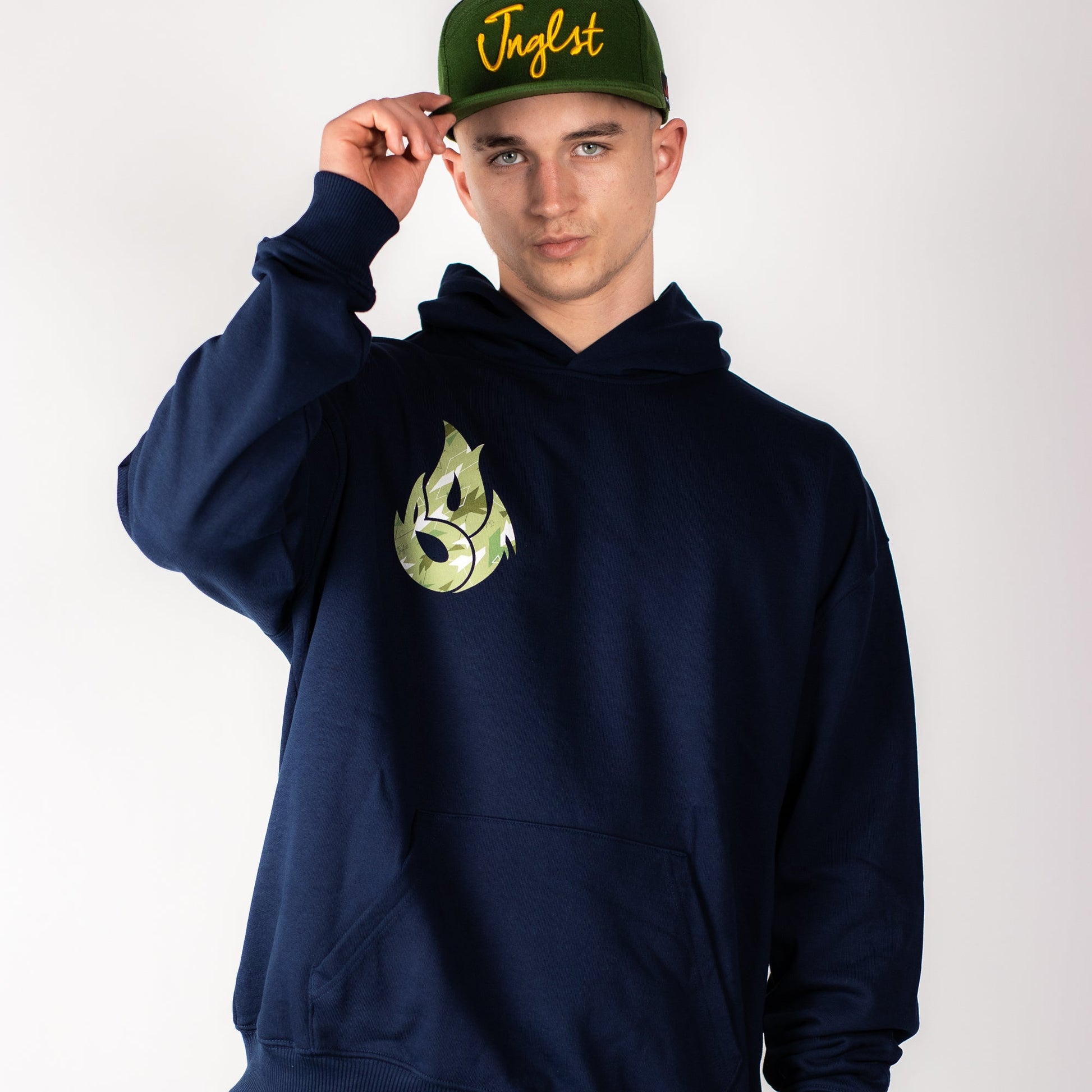 Person wearing a navy Junglist hoodie with a green logo and a green cap with yellow text on a white background