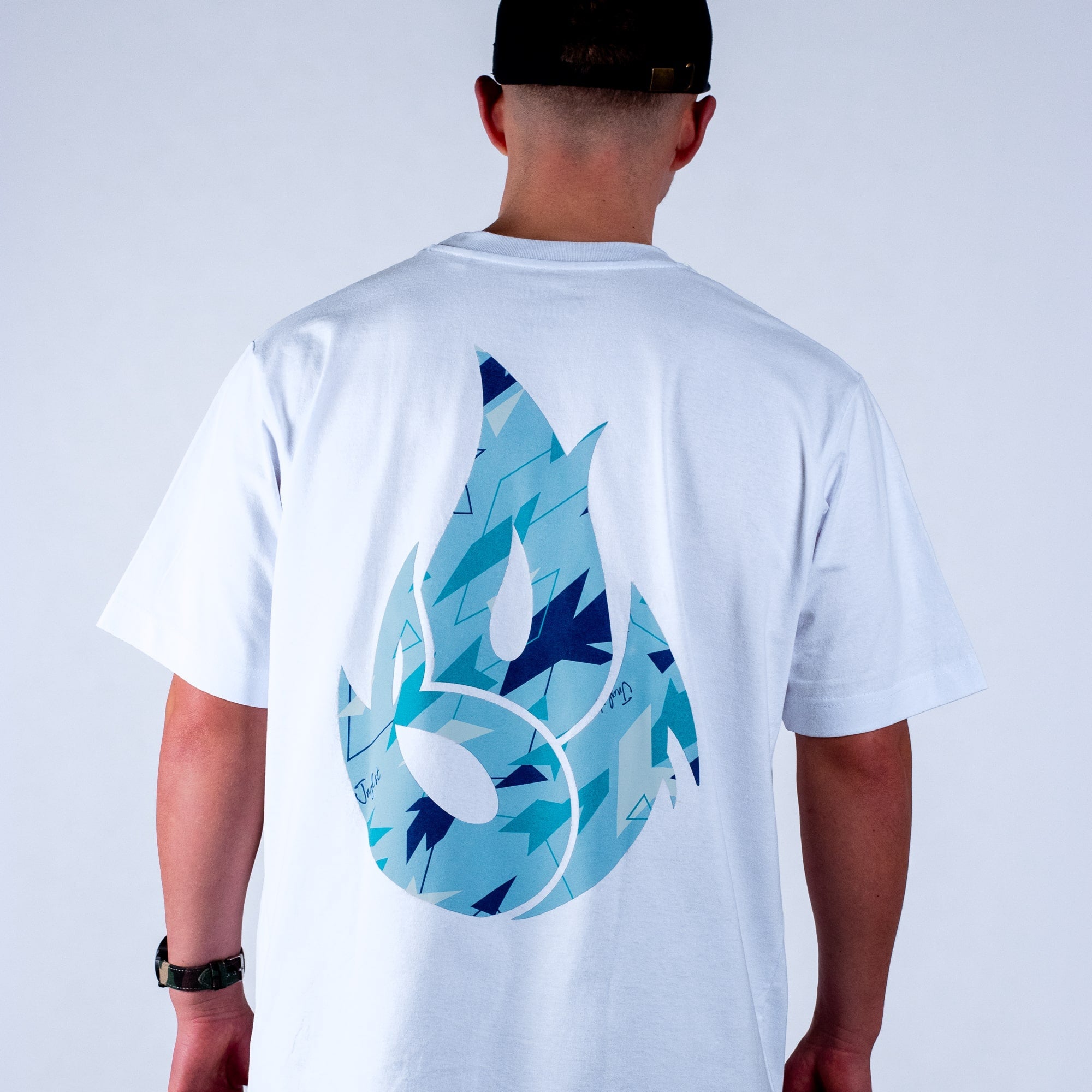 Person wearing a white t-shirt with a blue graphic design on the back against a plain background