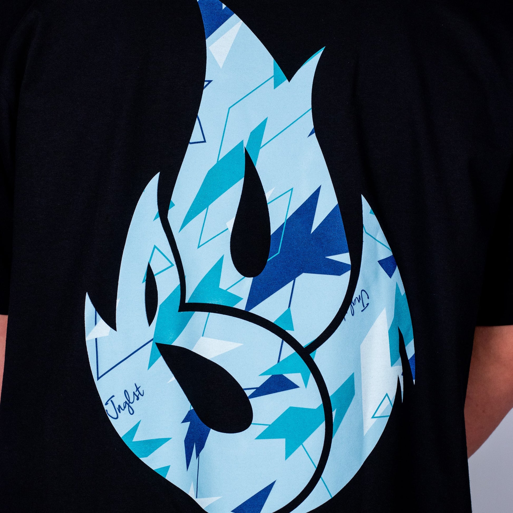 Black t-shirt with a blue and black camo flame design on a plain background