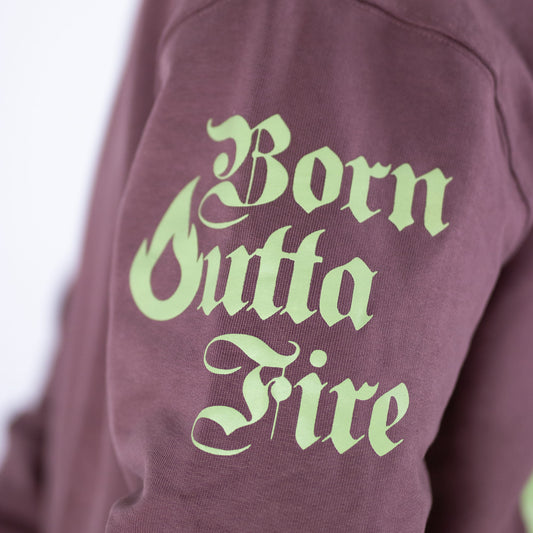 Maroon sweatshirt with 'Born Outta Fire' text in light green on a blurred background