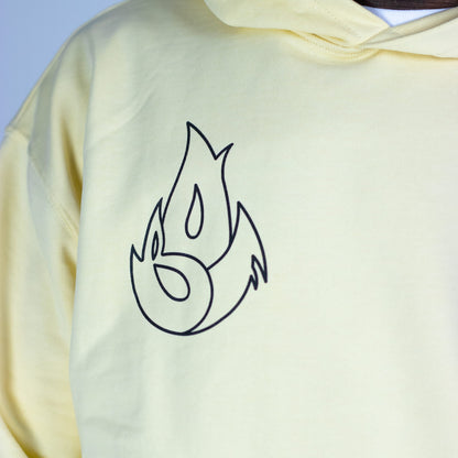 Light yellow hoodie with a black flame design on the chest against a light gray background