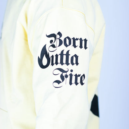 White sweatshirt with 'Born Outta Fire' text on a light blue background