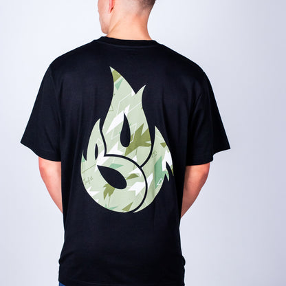 Person wearing a black Born Outta Fire t-shirt with a green camo flame design on the back against a plain background