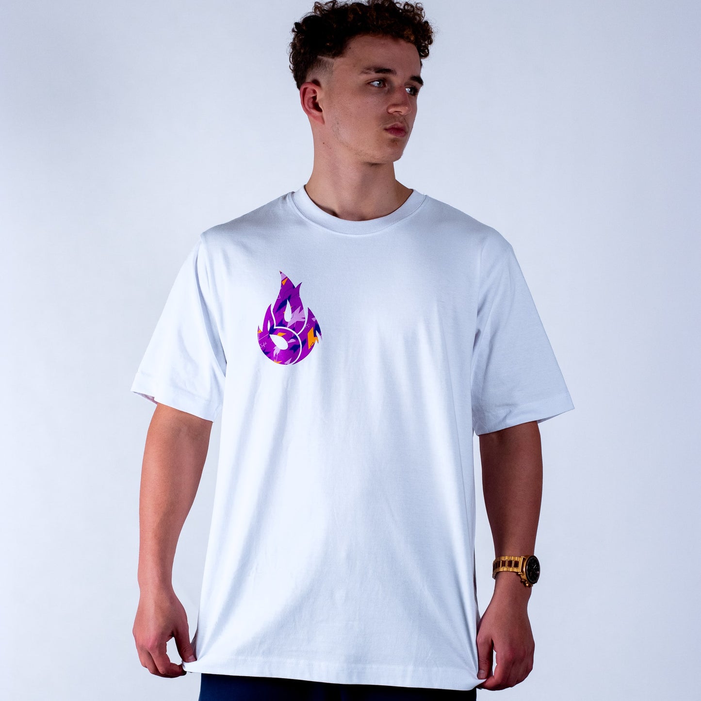 Person wearing a white t-shirt with a purple camo flame design on a plain background